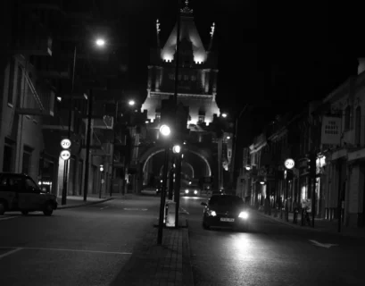 a black and white photo of a city street at night
