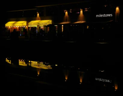 a building lit up at night with lights reflecting in the water