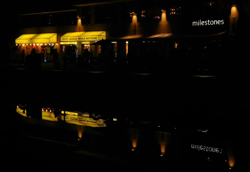 a building lit up at night with lights reflecting in the water