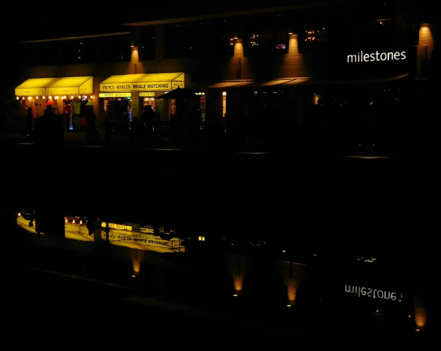 a building lit up at night with lights reflecting in the water