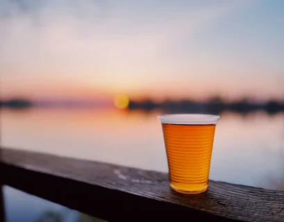 A cup of beer sitting on a wooden ledge