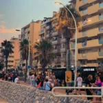 a group of people standing on the side of a road