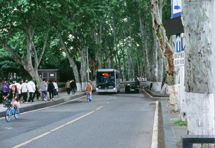 a group of people walking down a street next to a bus