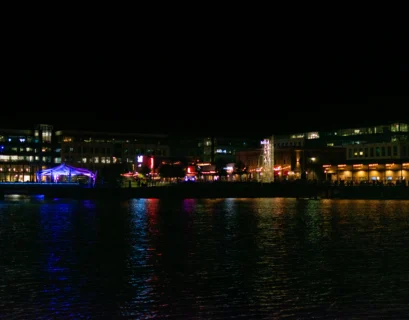a large body of water at night with buildings in the background