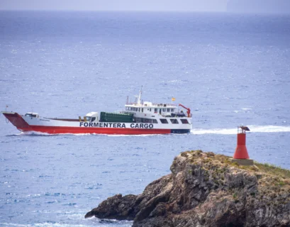 a red and white boat traveling across a body of water