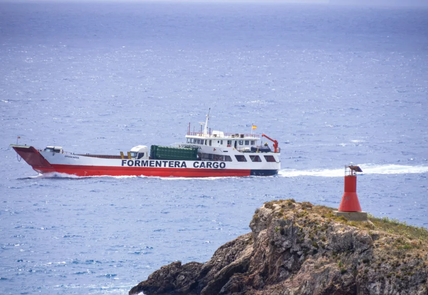 a red and white boat traveling across a body of water