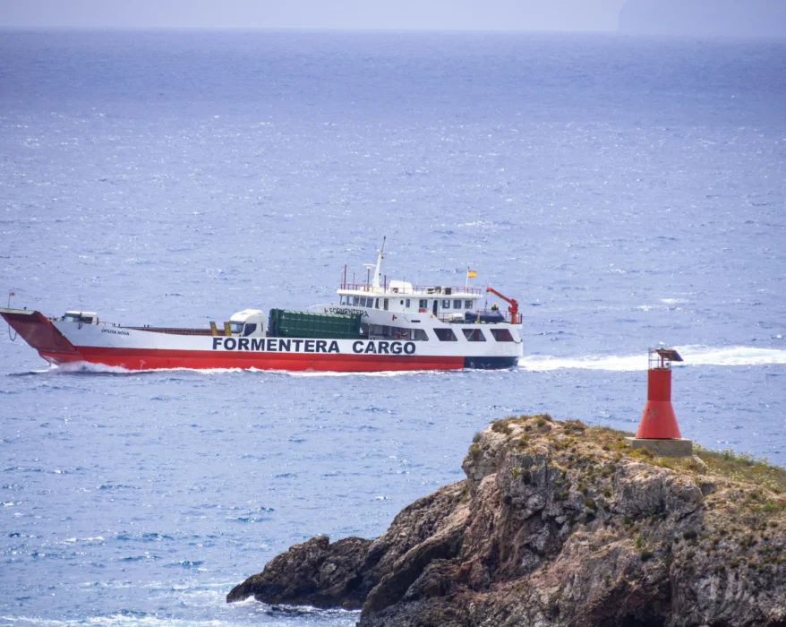 a red and white boat traveling across a body of water