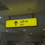 A yellow sign hanging from the ceiling of a building