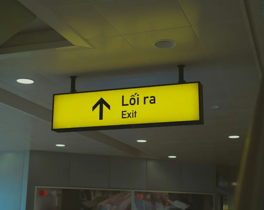A yellow sign hanging from the ceiling of a building