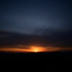 silhouette of mountain under cloudy sky during sunset