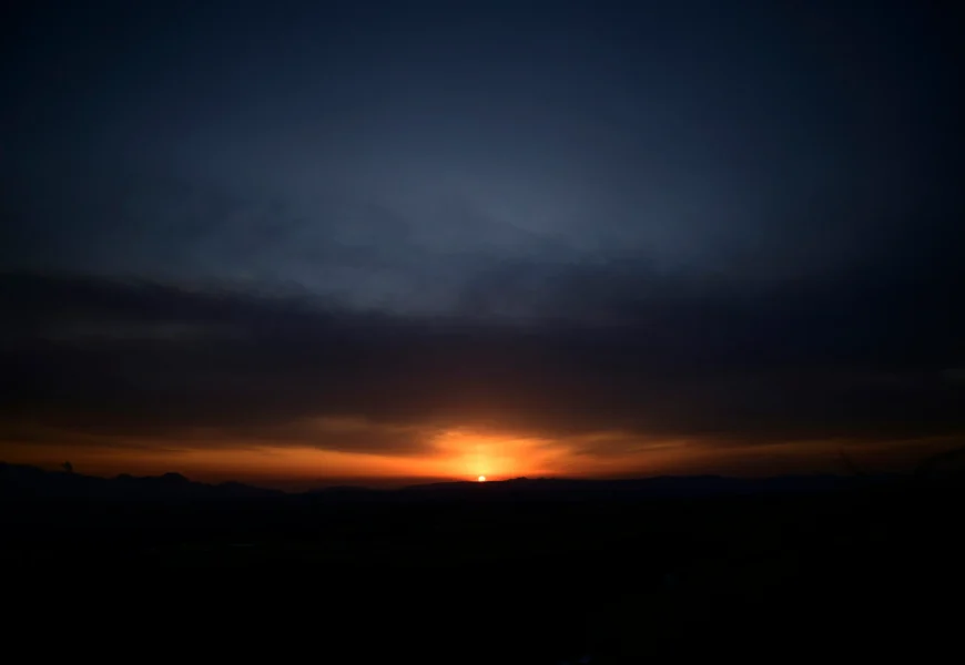 silhouette of mountain under cloudy sky during sunset