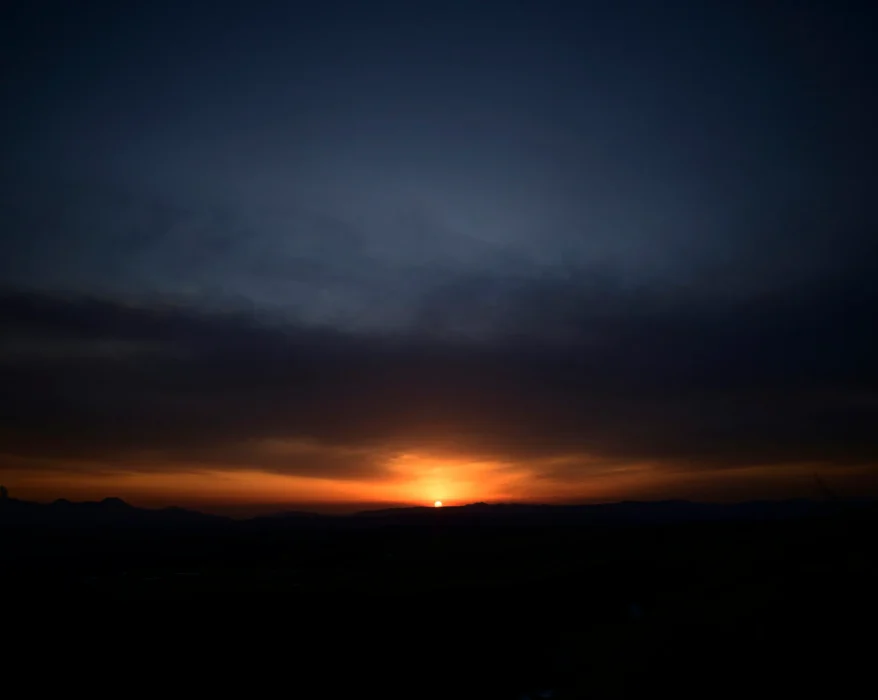 silhouette of mountain under cloudy sky during sunset