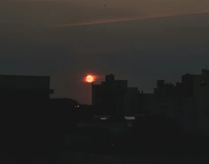 the sun is setting over a city skyline