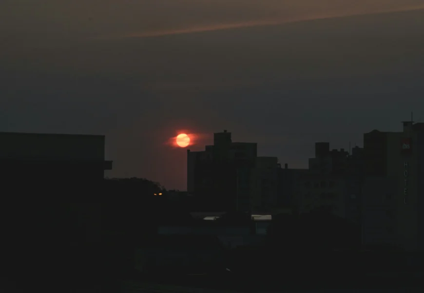 the sun is setting over a city skyline