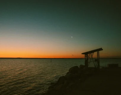 the sun is setting over the water at the beach