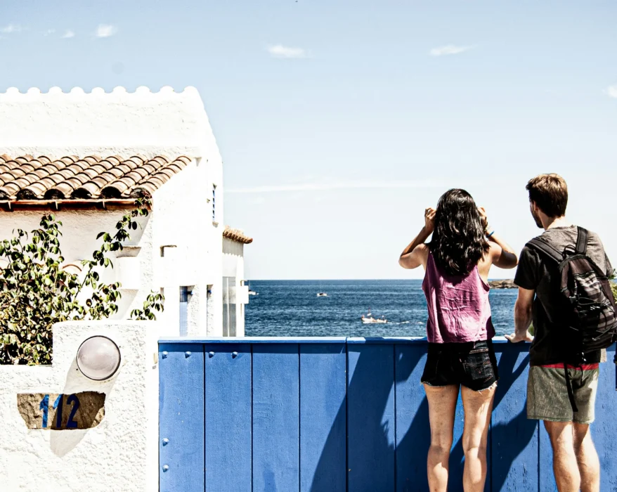 woman in pink and black tank top and blue denim shorts standing on blue metal railings